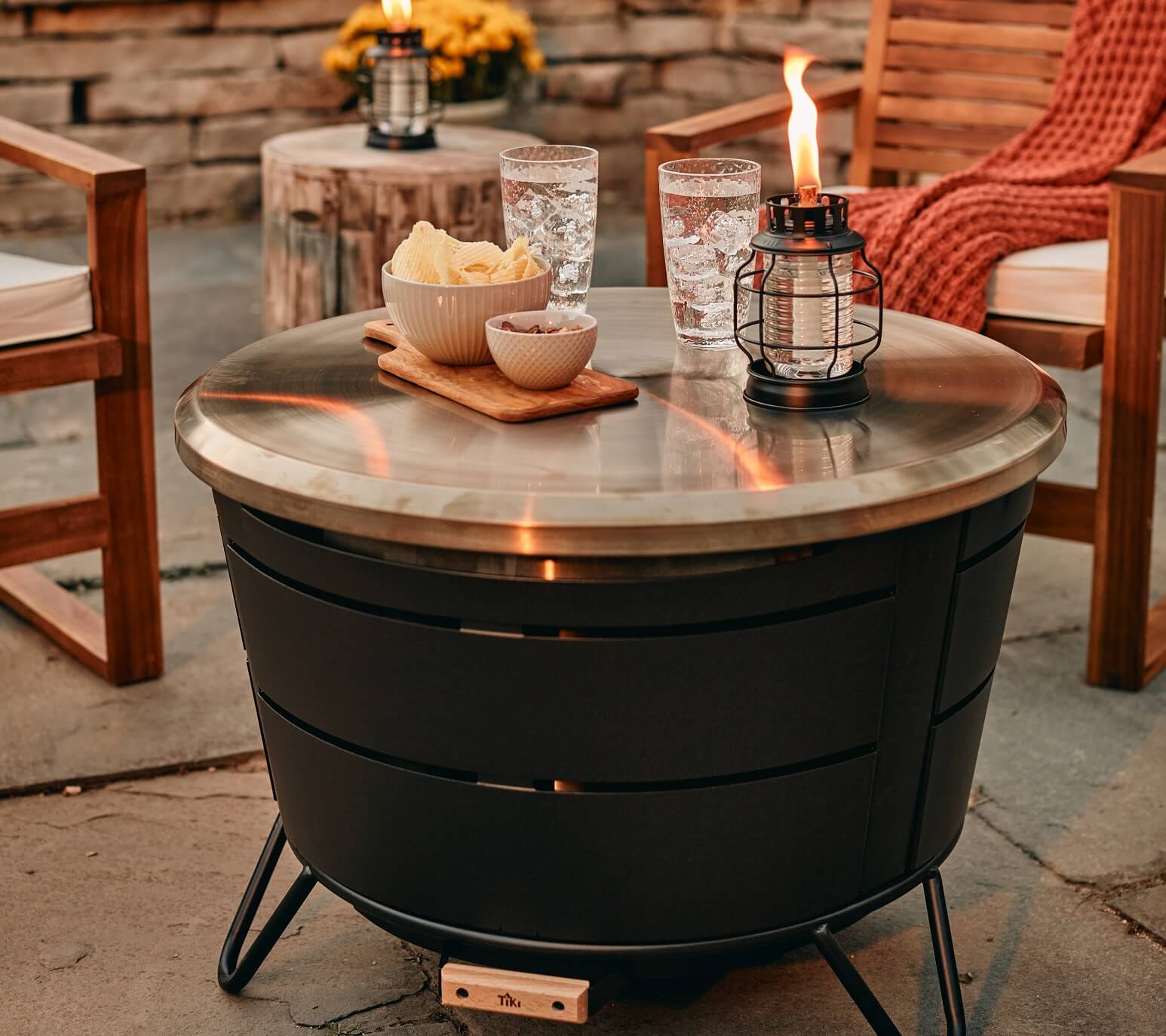Couple adding TIKI Wood Pack to a fire pit