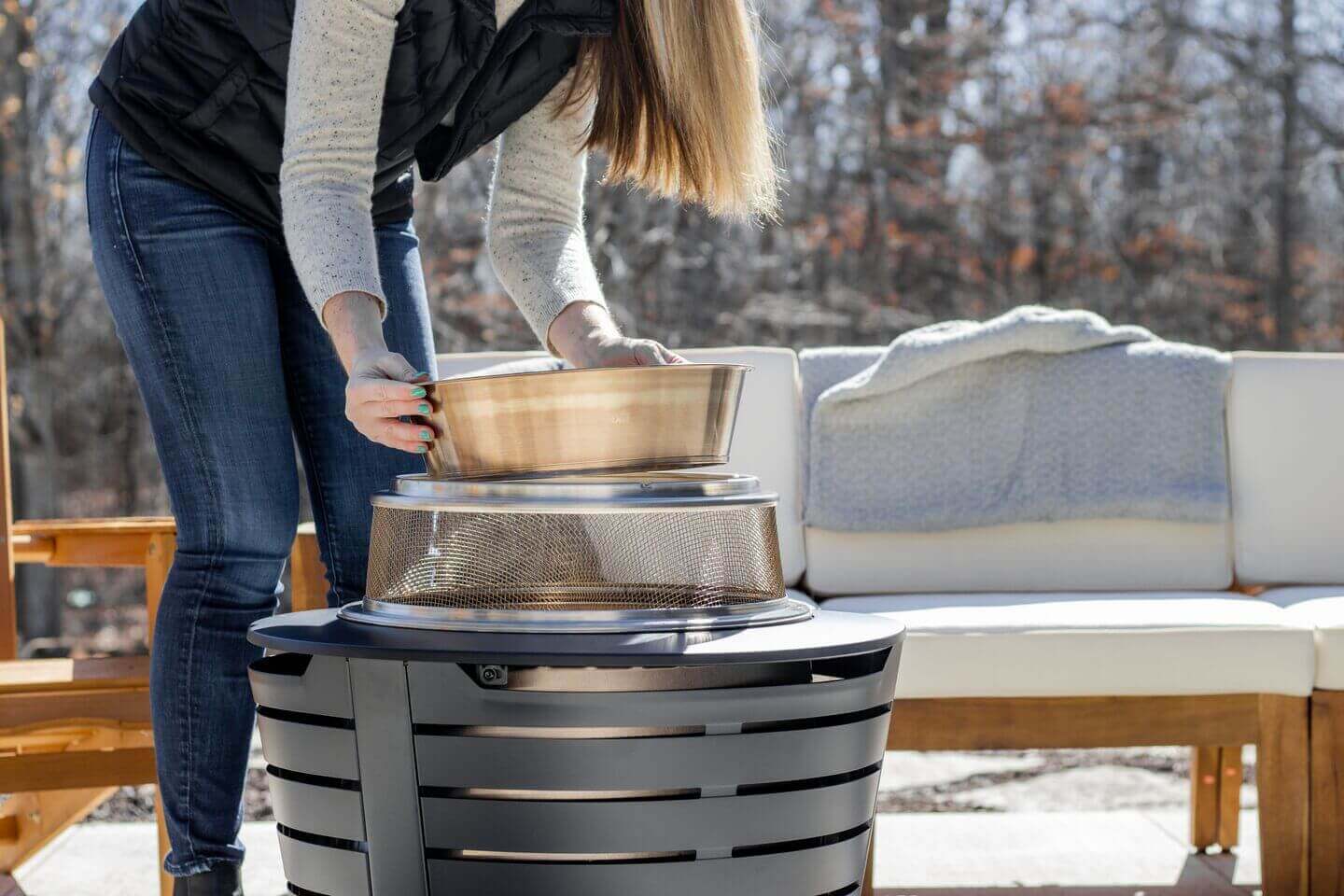 Woman putting the heat deflecter in the patio fire pit