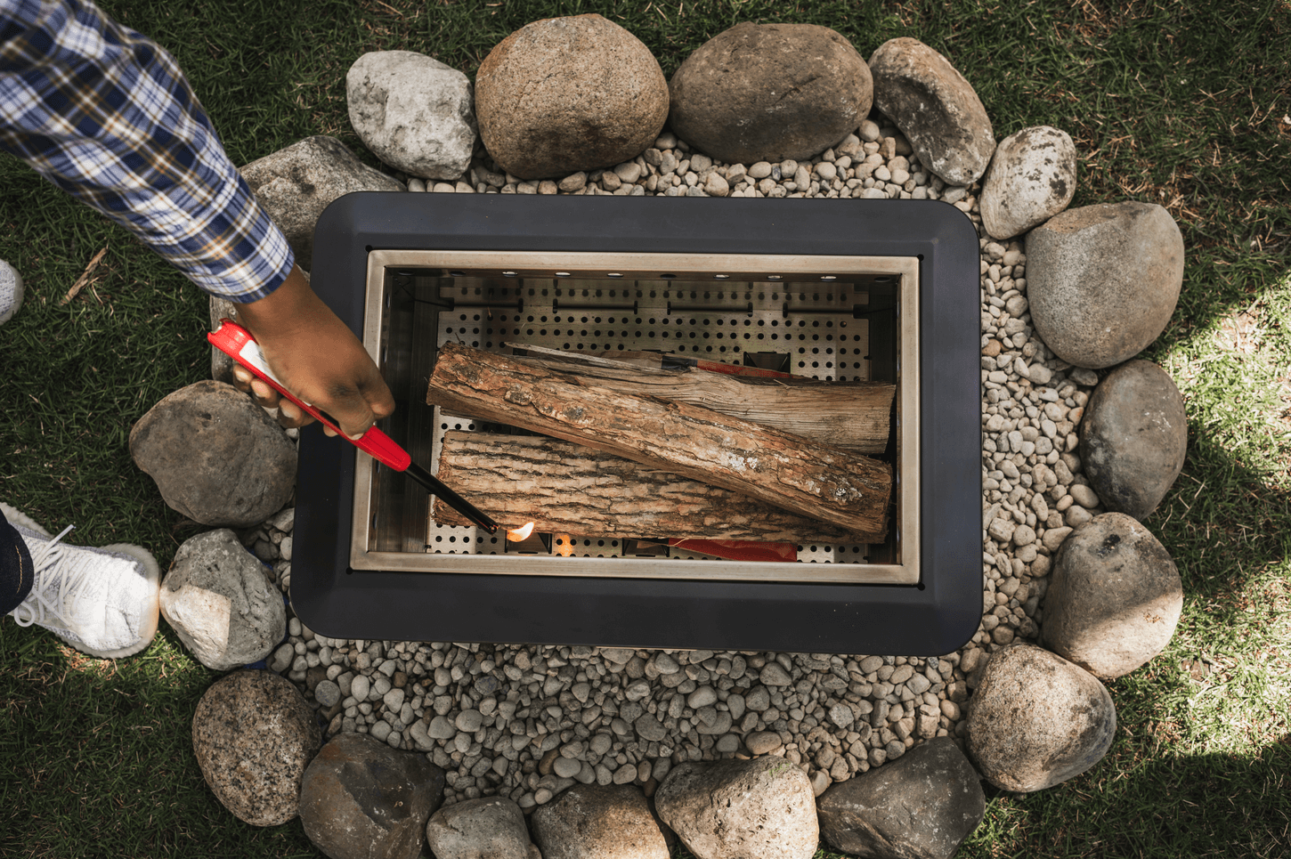 portable smokeless fire pit being lit with wood logs and wood pellets