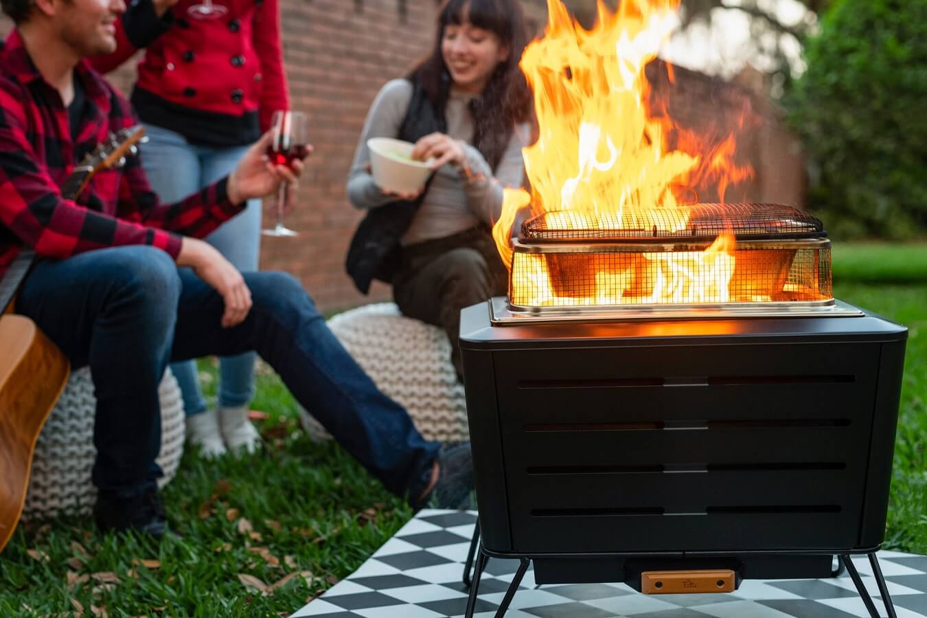 friends drinking wine, playing guitar, around portable smokeless fire pit